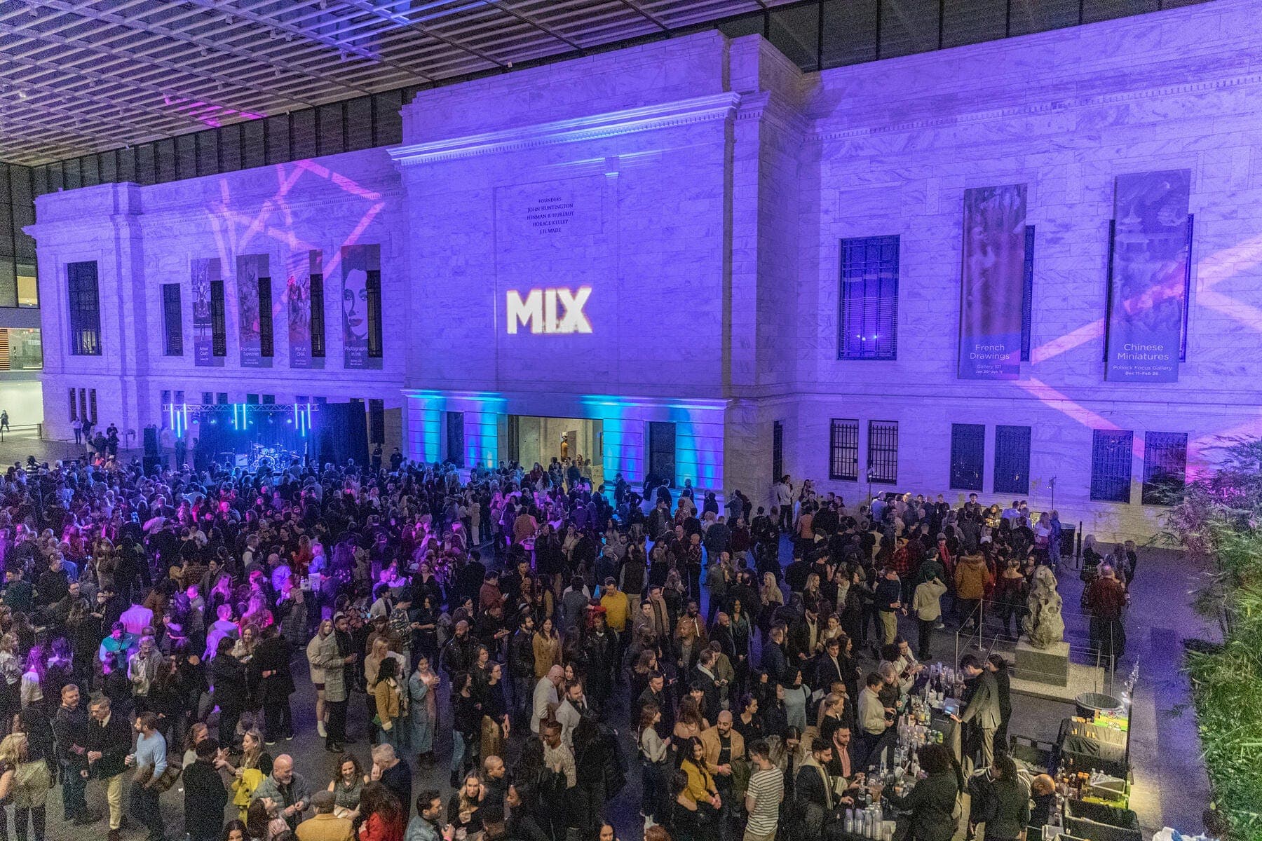 a large group of people in front of a purple building