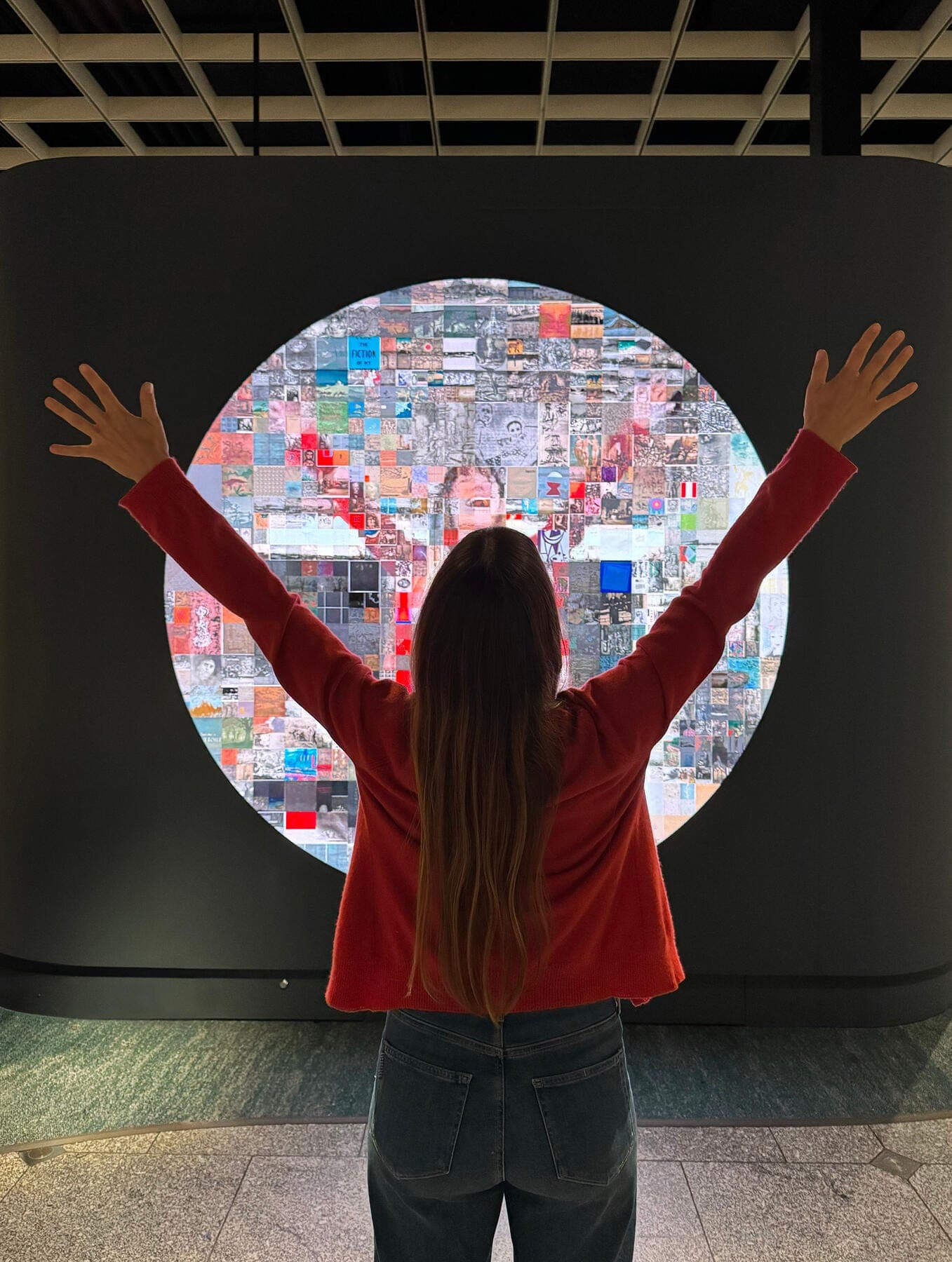 a person with the hands up in front of a large screen
