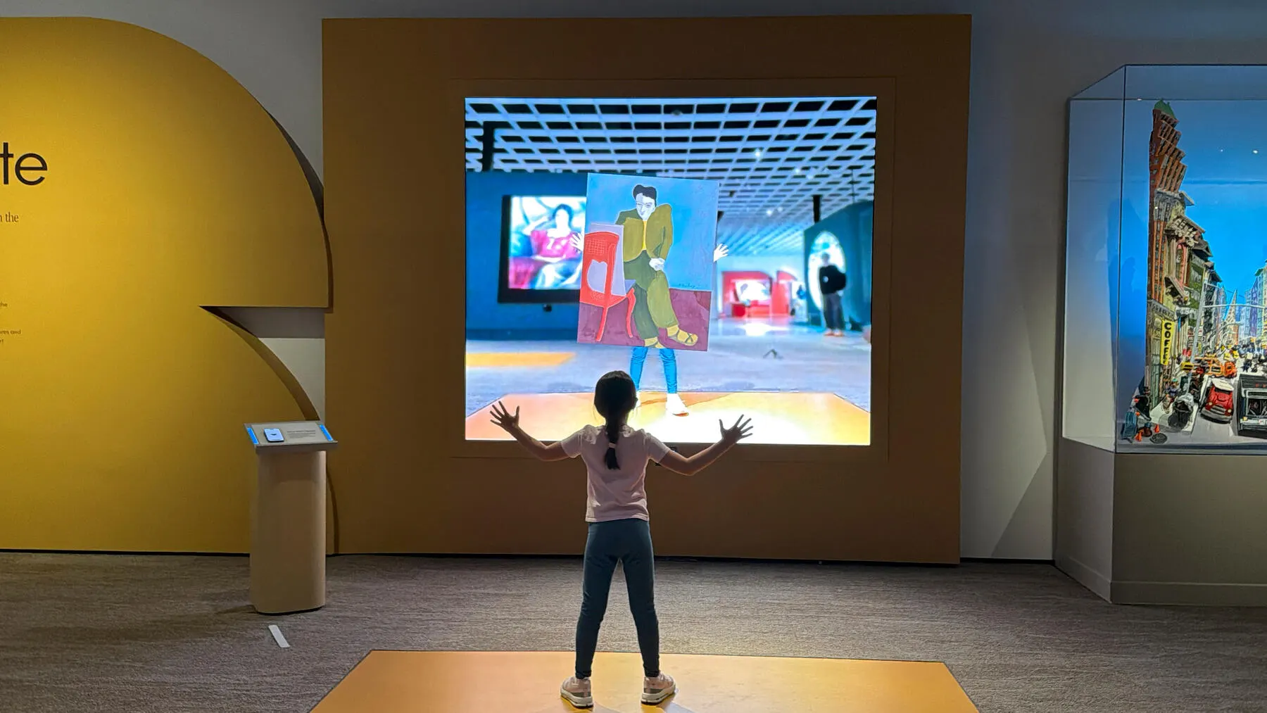 a girl standing in front of a large screen