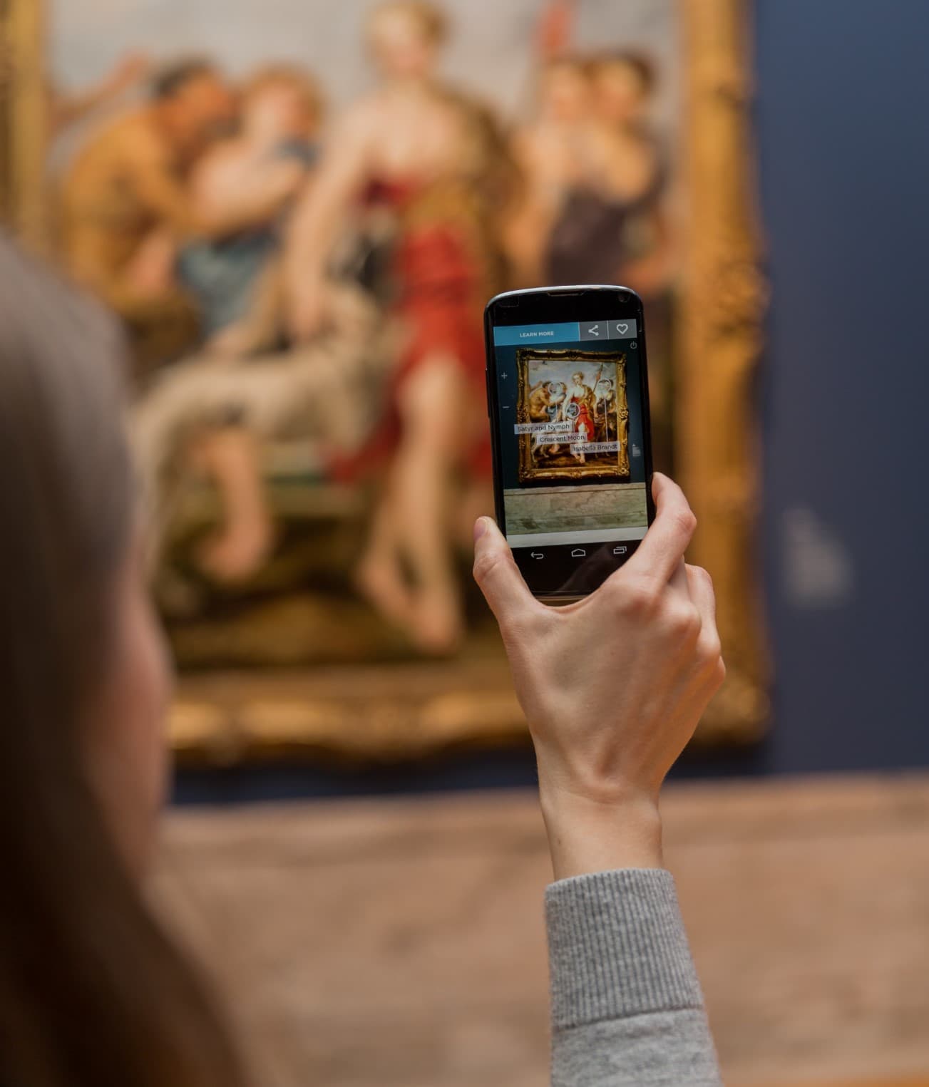 A person holding up their phone to a painting
