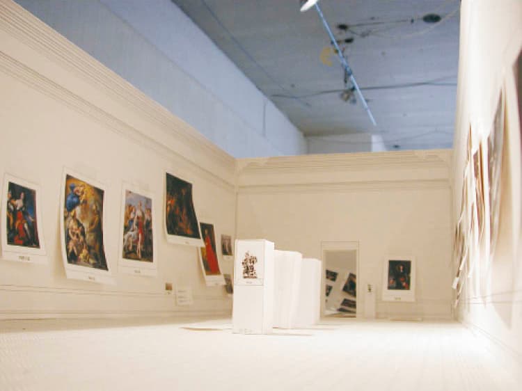 This 2004 photograph shows how designers used scaled color images of paintings and a scale model of the future museum to begin planning the installation of the renovated
Reinberger Gallery in the 1916 building.