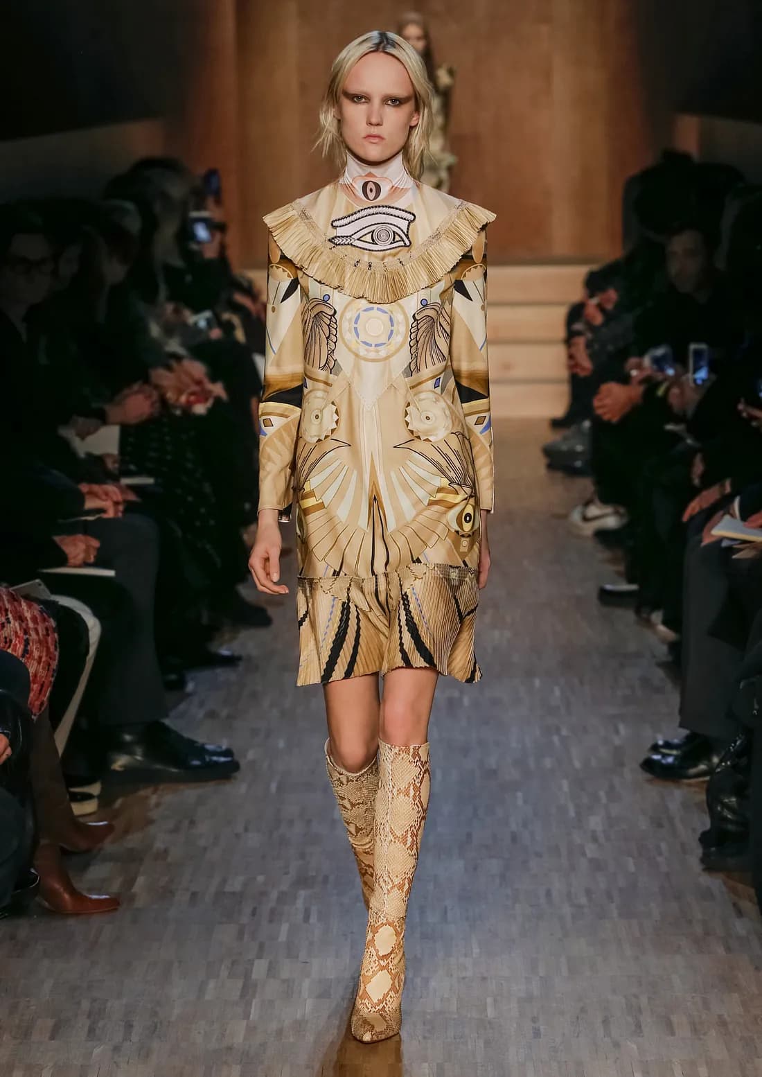 a woman with blonde hair modeling and walking down a runway