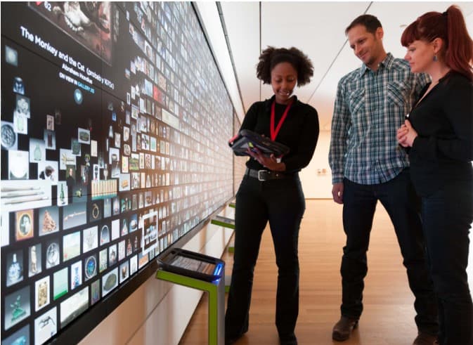 An artlens tech helping visitors