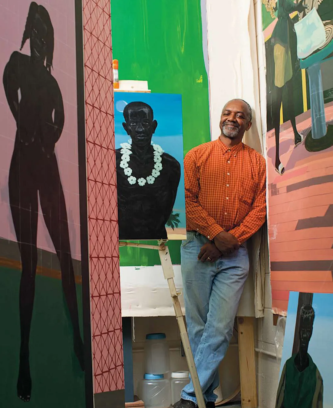 Kerry James Marshall surrounded by paintings.