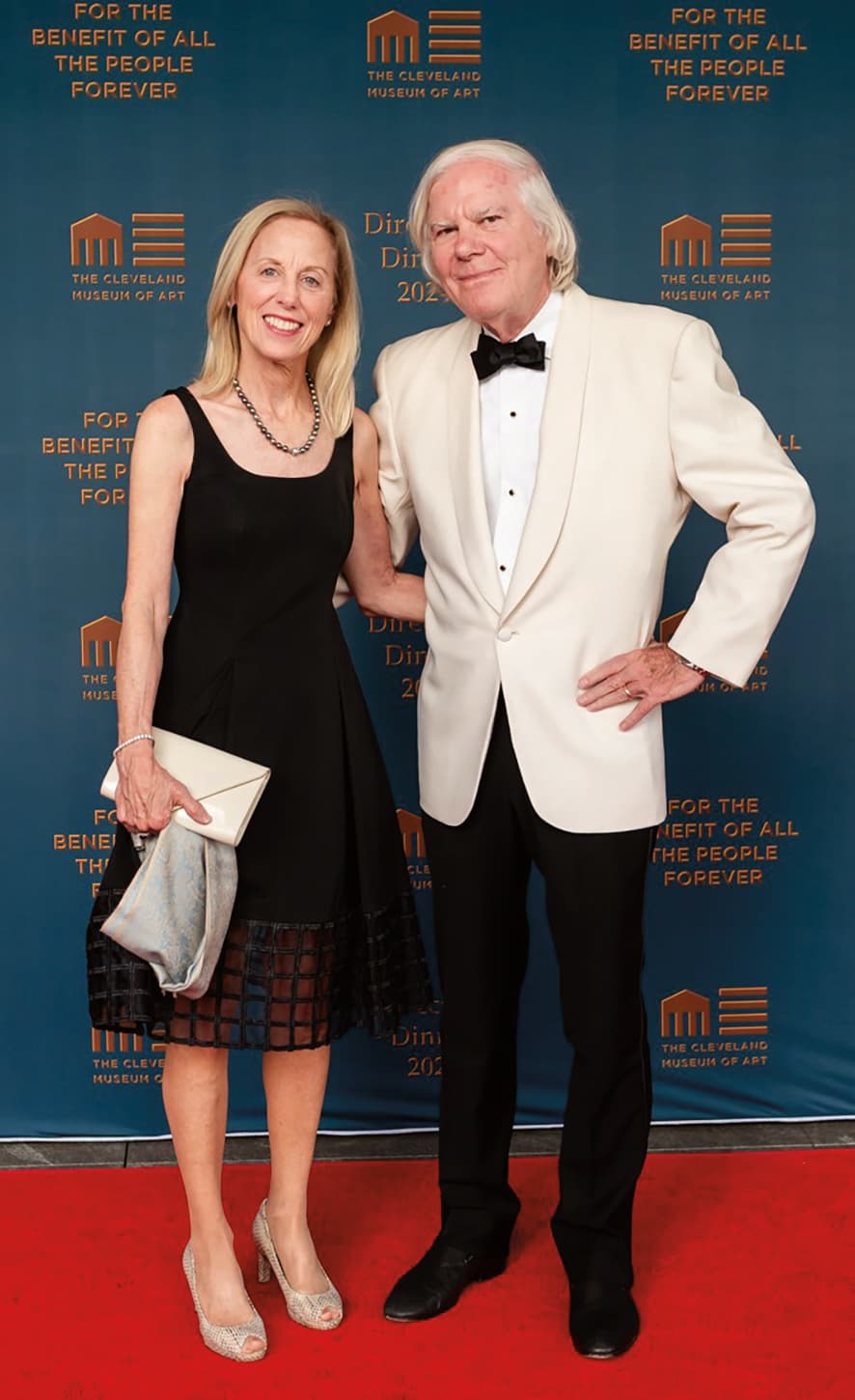 An elderly couple posing on a red carpet.