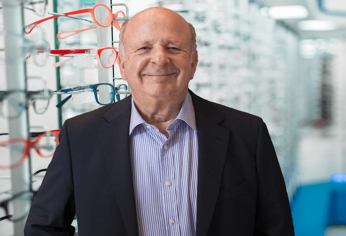 Photo of a man with a black suit and blue striped shirt