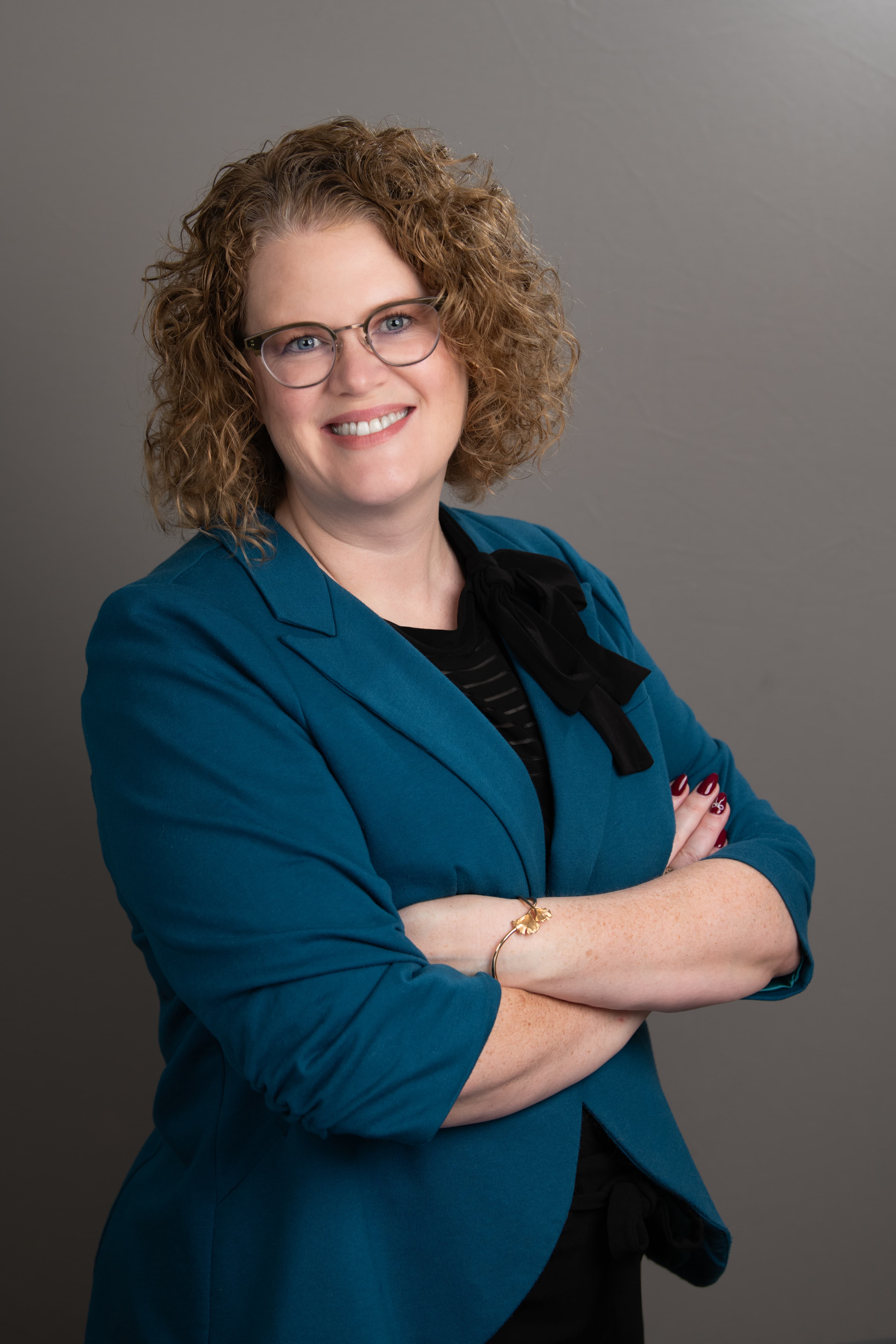 Portrait of a woman crossing her arms wearing a blue blazer