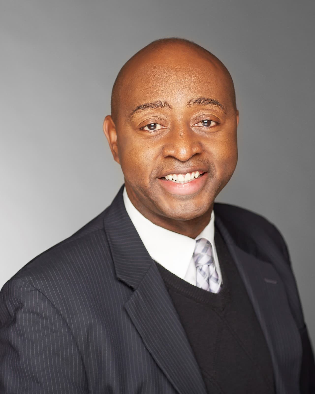 Headshot of a man in a black suit