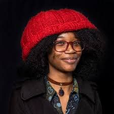 Headshot of a woman wearing a red hat
