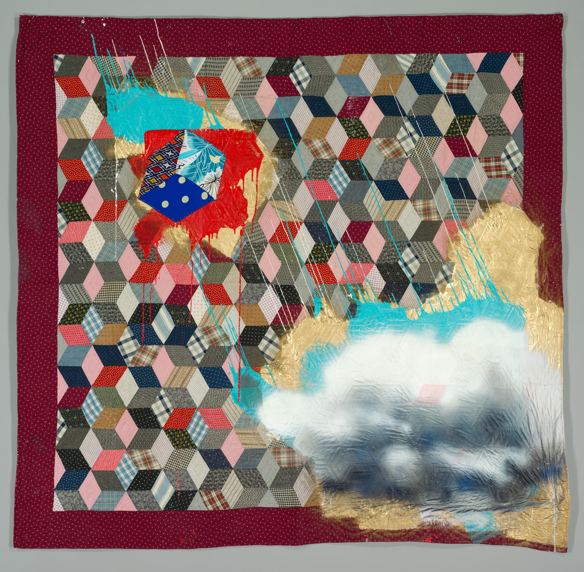 Spray paint and acrylic cover a square quilt patterned with pink, gray, and blue three-dimensional cubes.