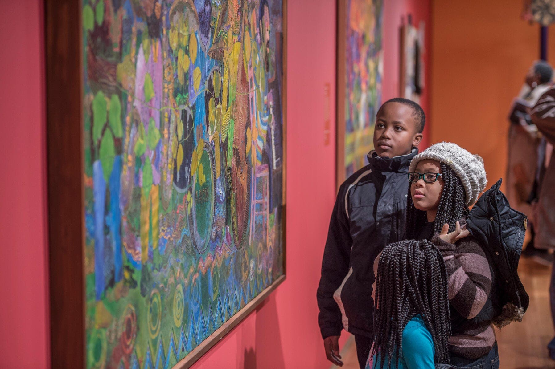 Three children looking at a painting in the gallery.