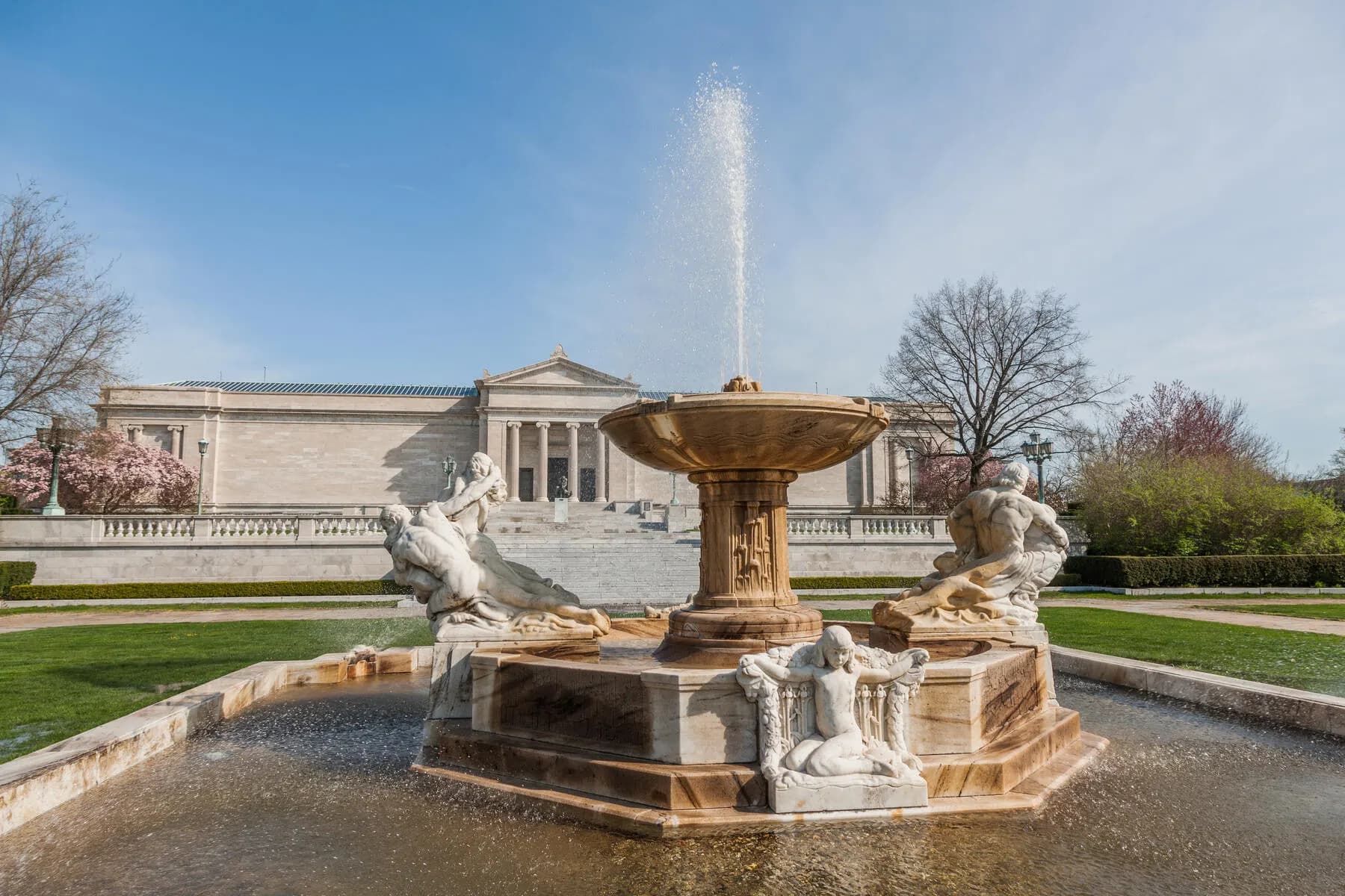 a fountain with statues in front of a building