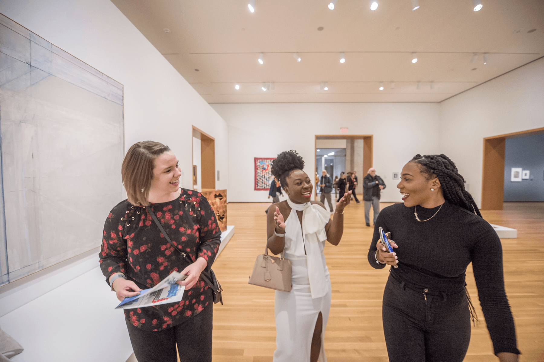 a group of women talking in a hallway
