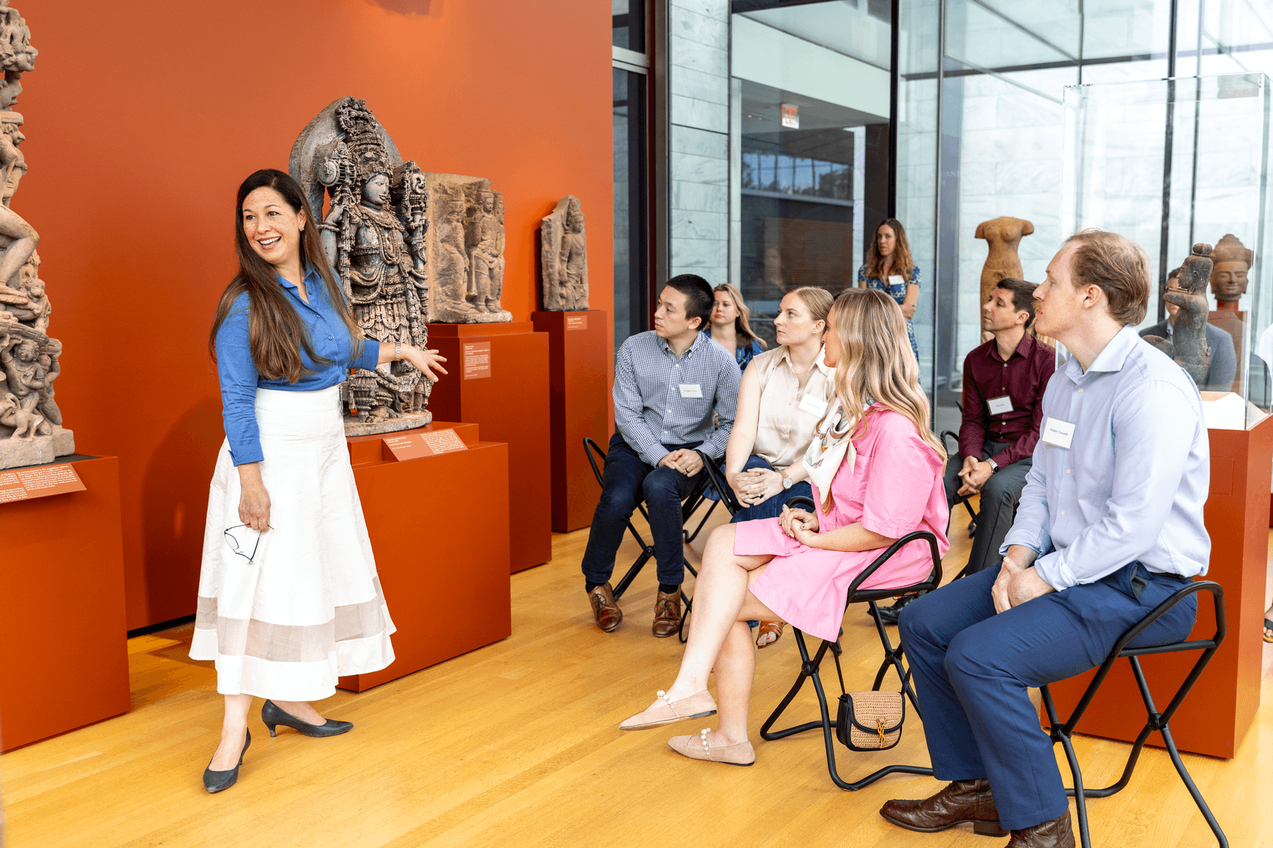 a person standing in front of a group of people sitting in chairs
