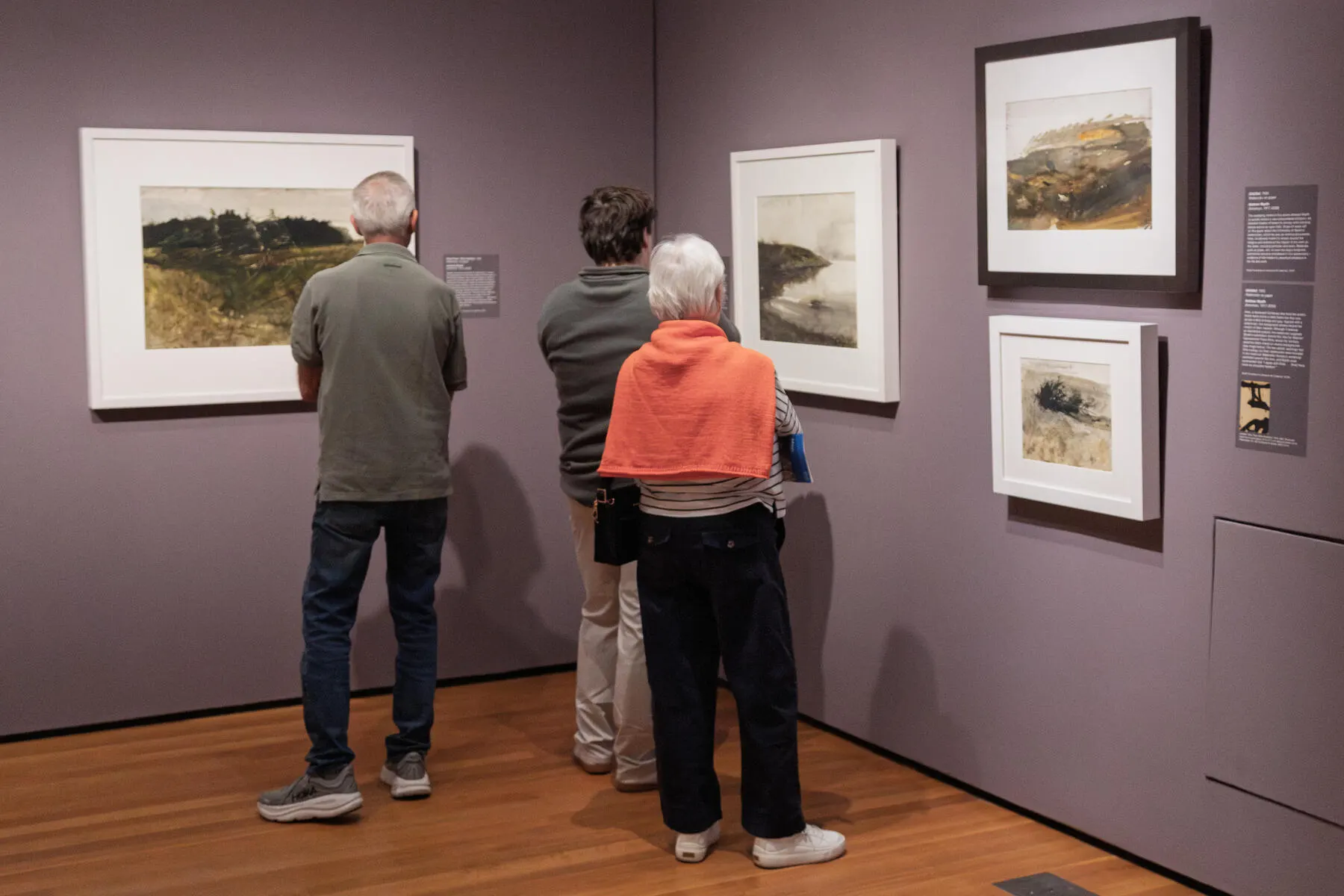 a group of people looking at art on the wall