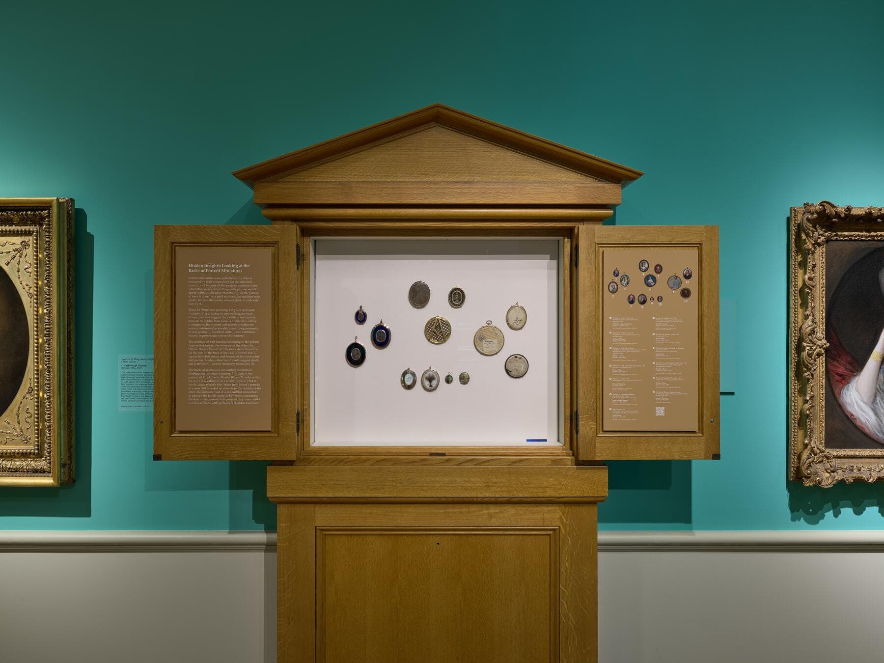 Gallery view of an artwork installation that includes 13 miniature British portraits.