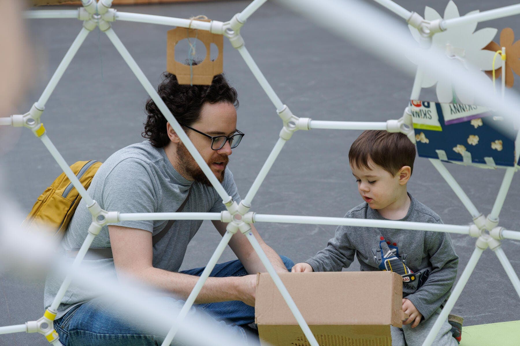 a person and a boy sitting on the ground making art
