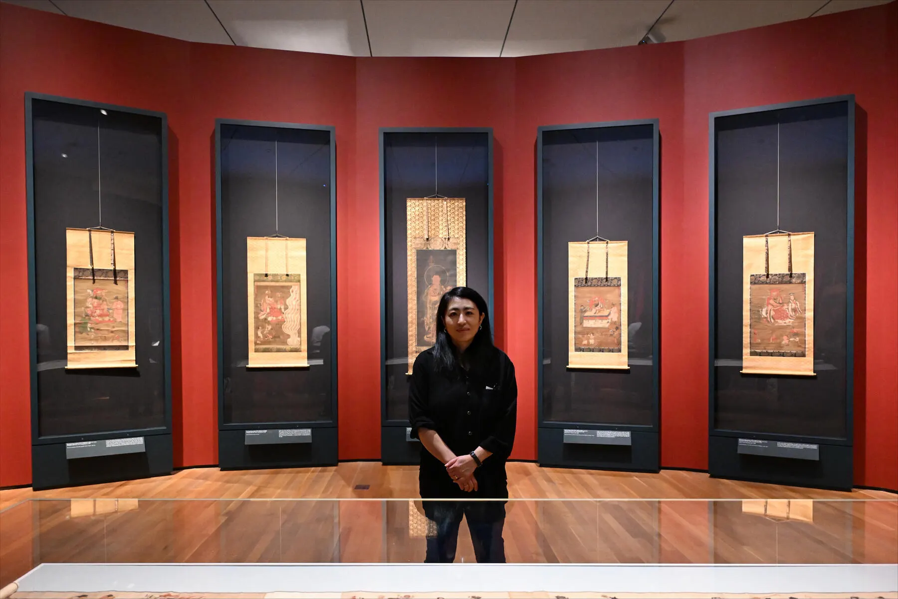 a person standing in front of a wall of paintings