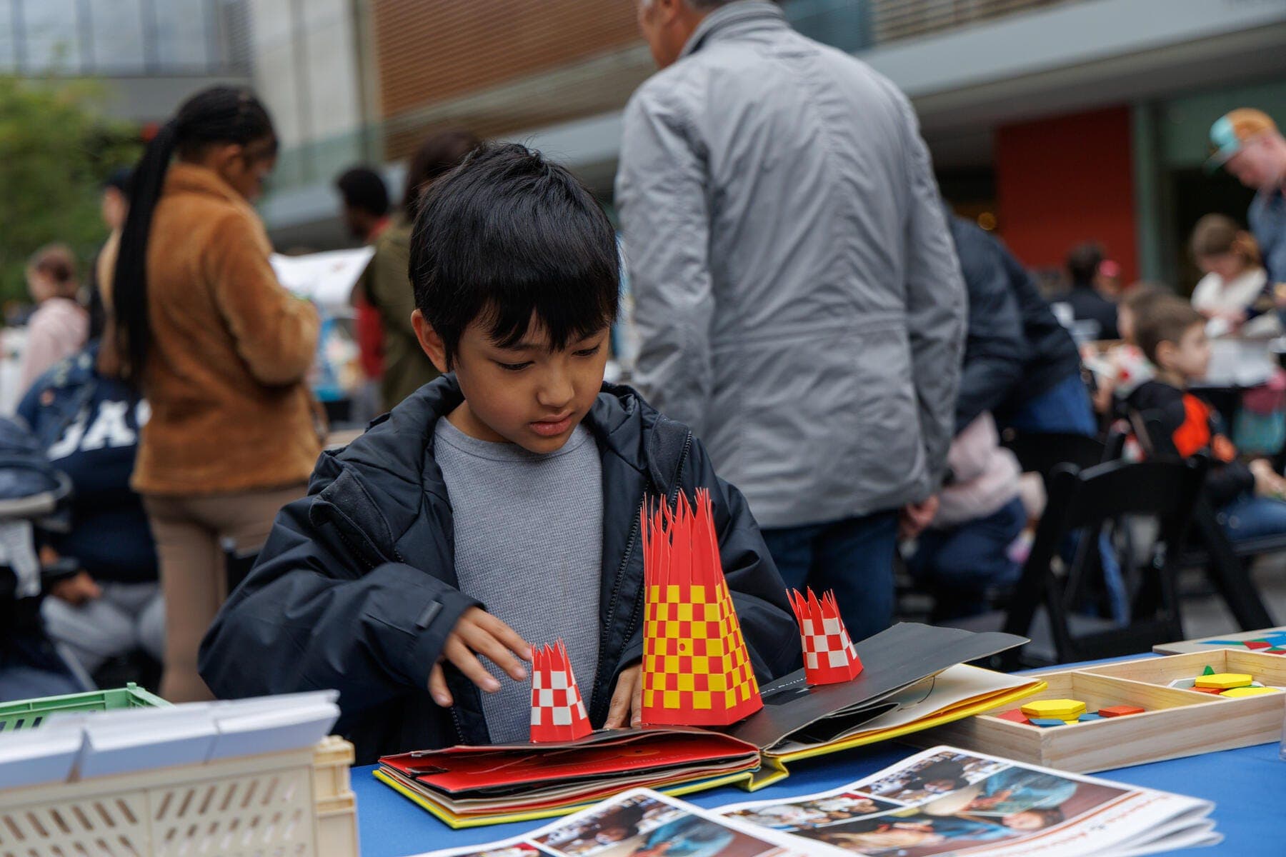 a boy sitting at a table with a book and a flag