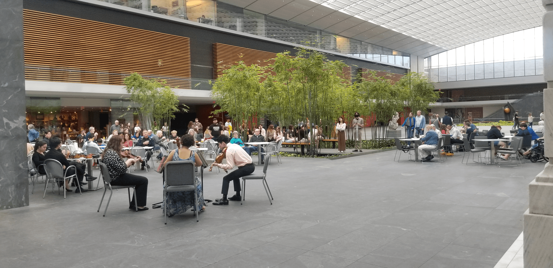 a group of people sitting at tables outside