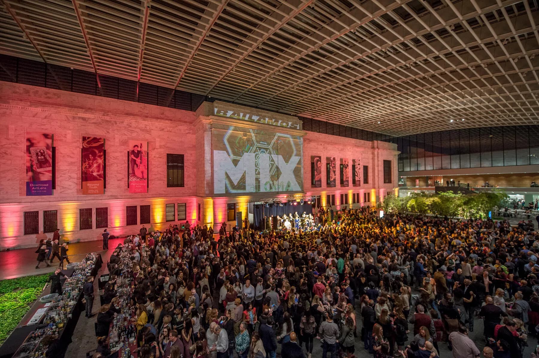 a large group of people in a large room with a stage and a large crowd