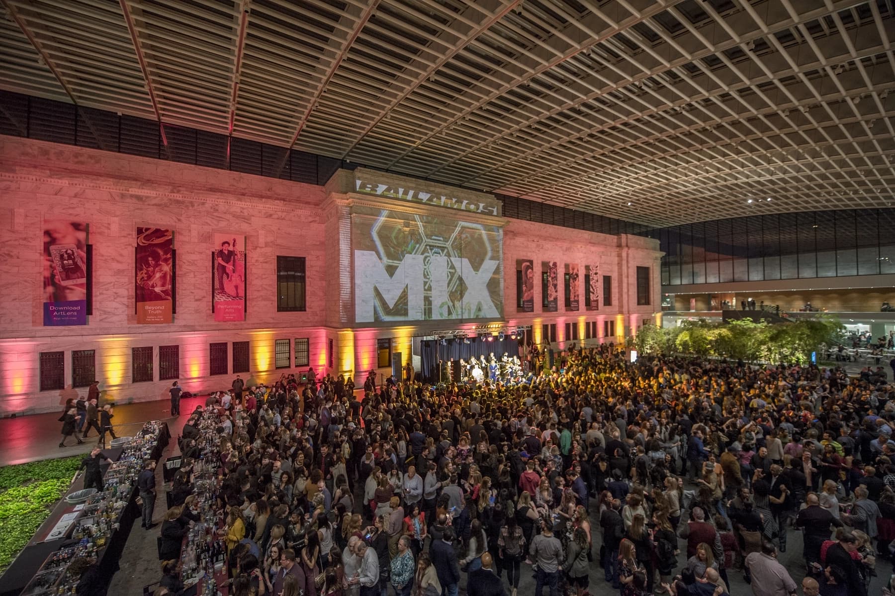 a large group of people in a large room with a stage and a large crowd