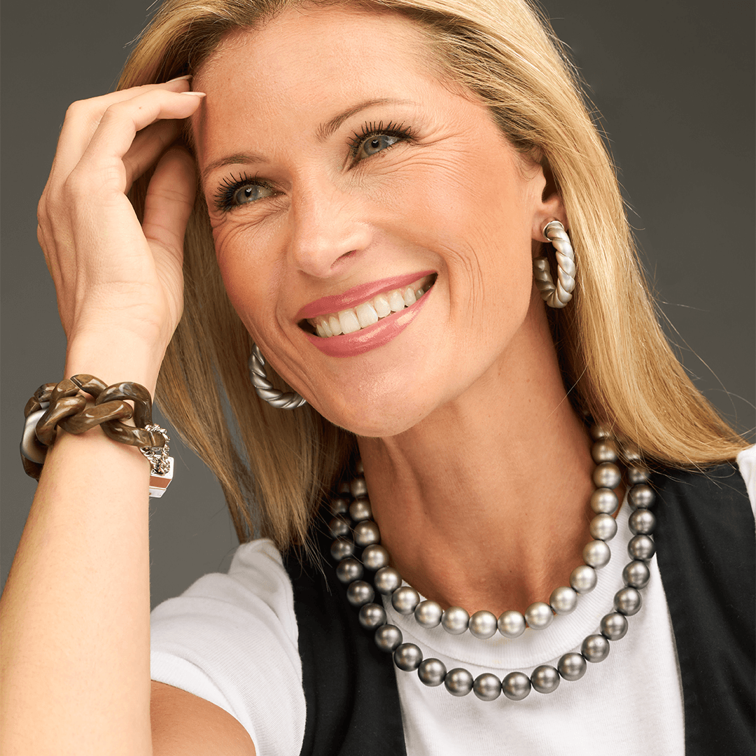 a woman smiling with her hand on her head