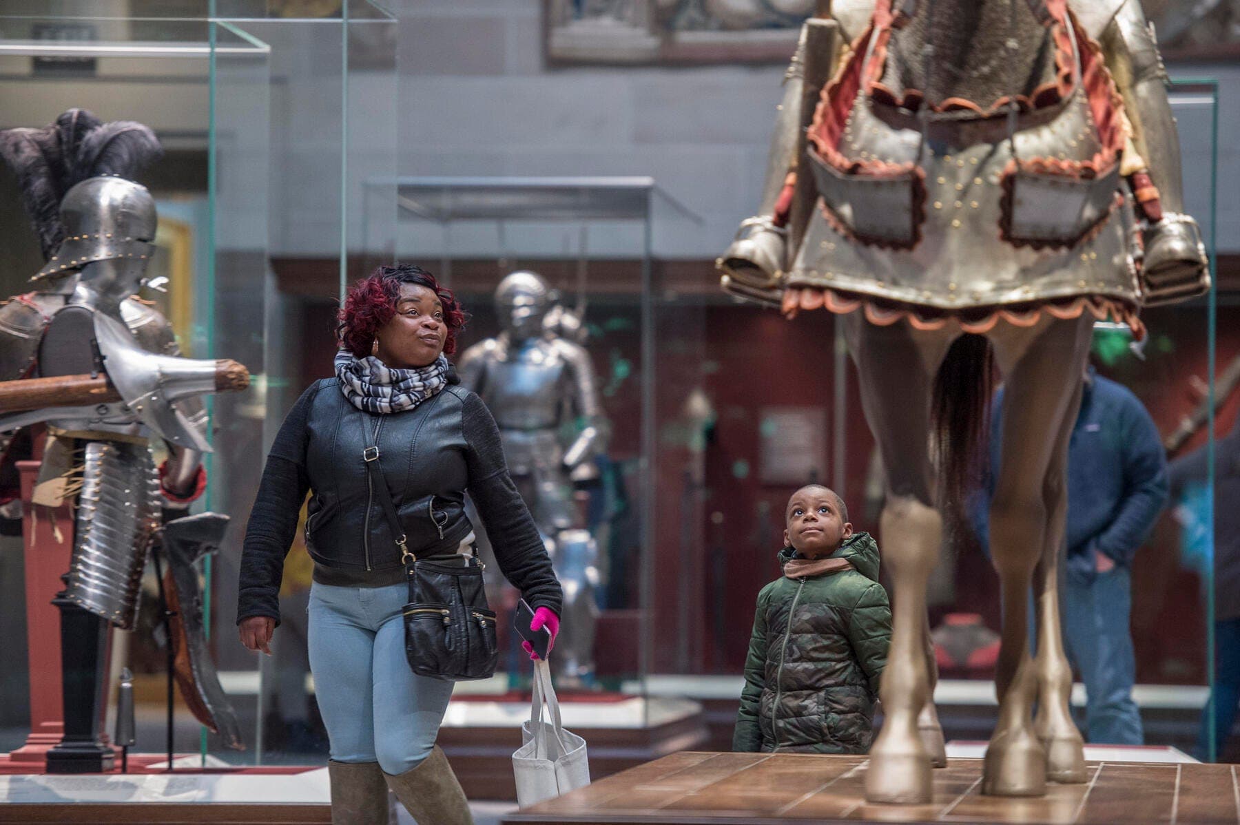 a person walking past statues