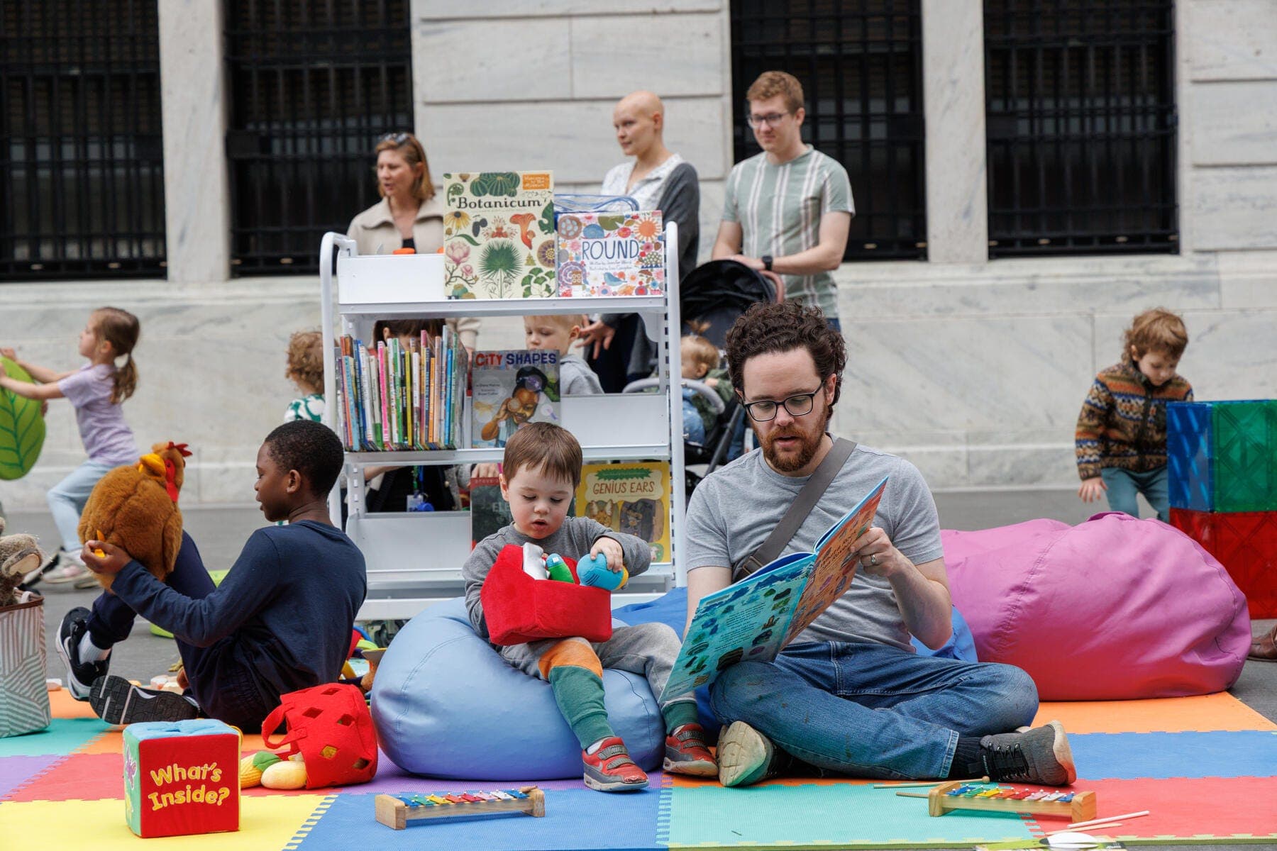 a man and children sitting on the ground with a man and a woman