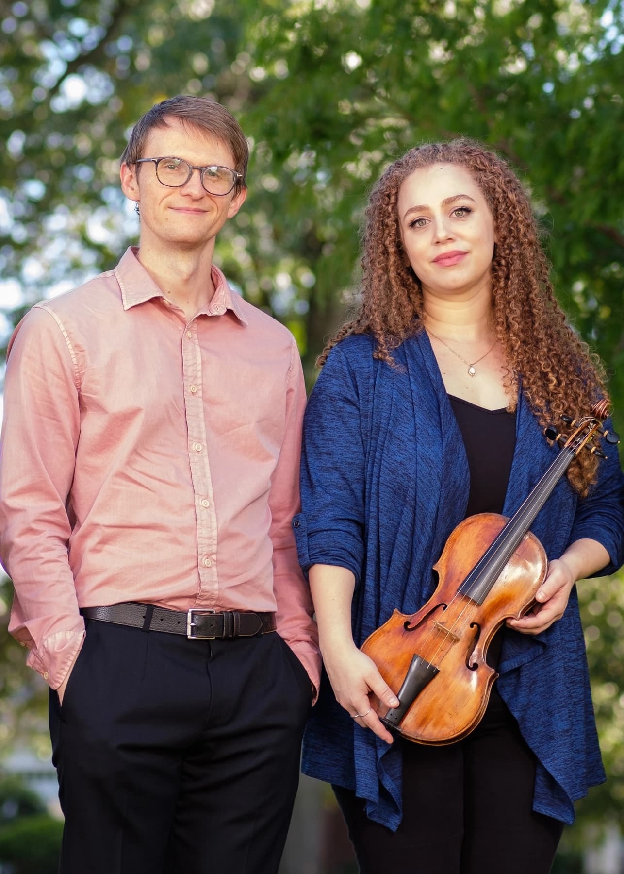 a man and a woman holding a violin