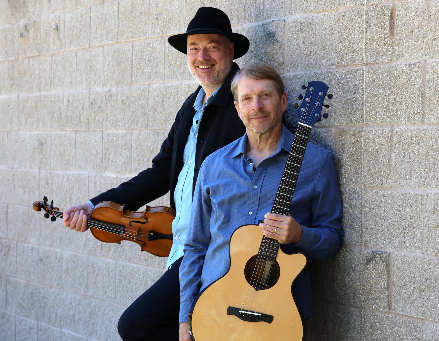 a couple of men holding guitars