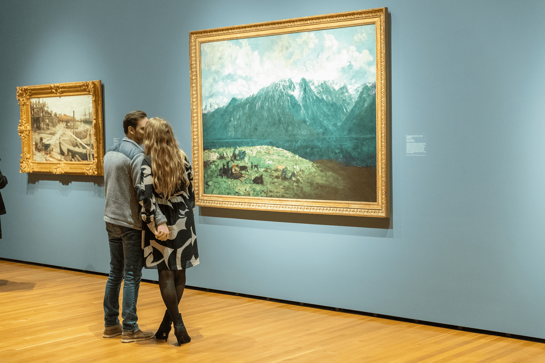 a man and woman looking at art on a wall