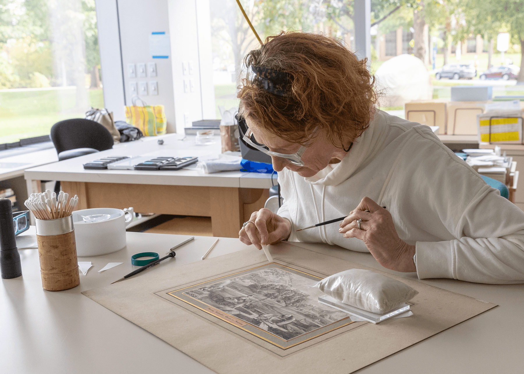 a person sitting at a table writing on a piece of paper