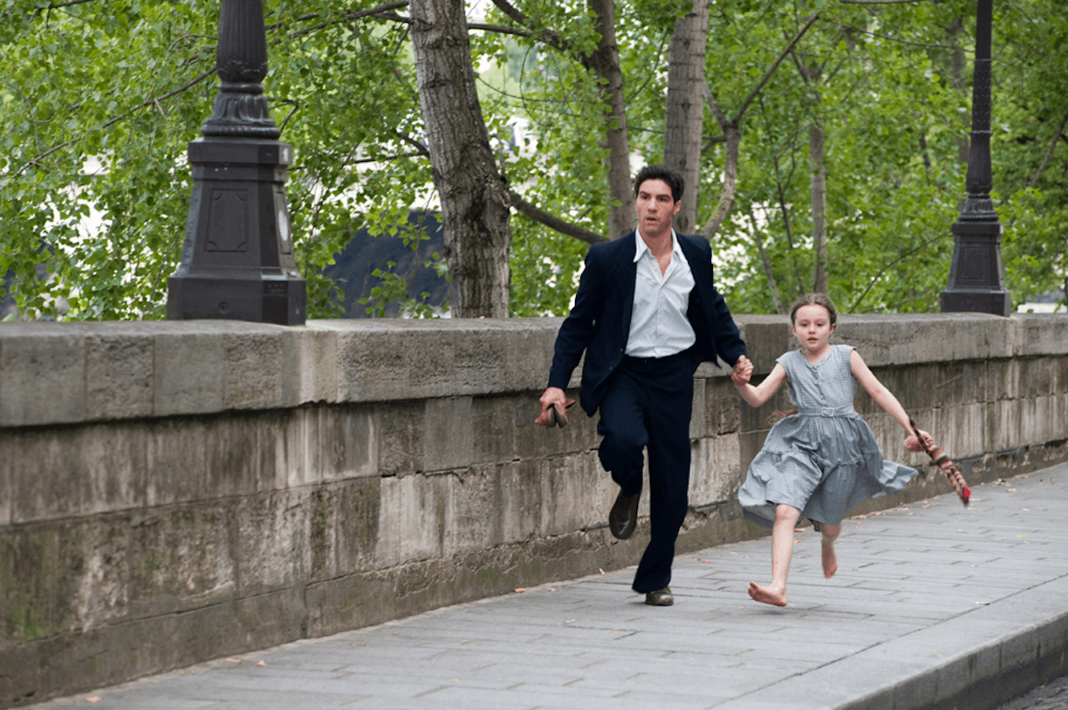 Tahar Rahim et al. running on a stone wall