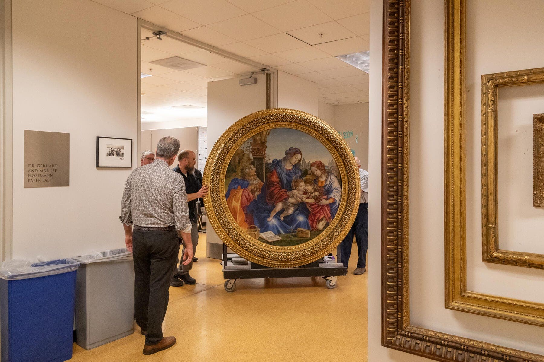 a group of people looking at a painting in a museum