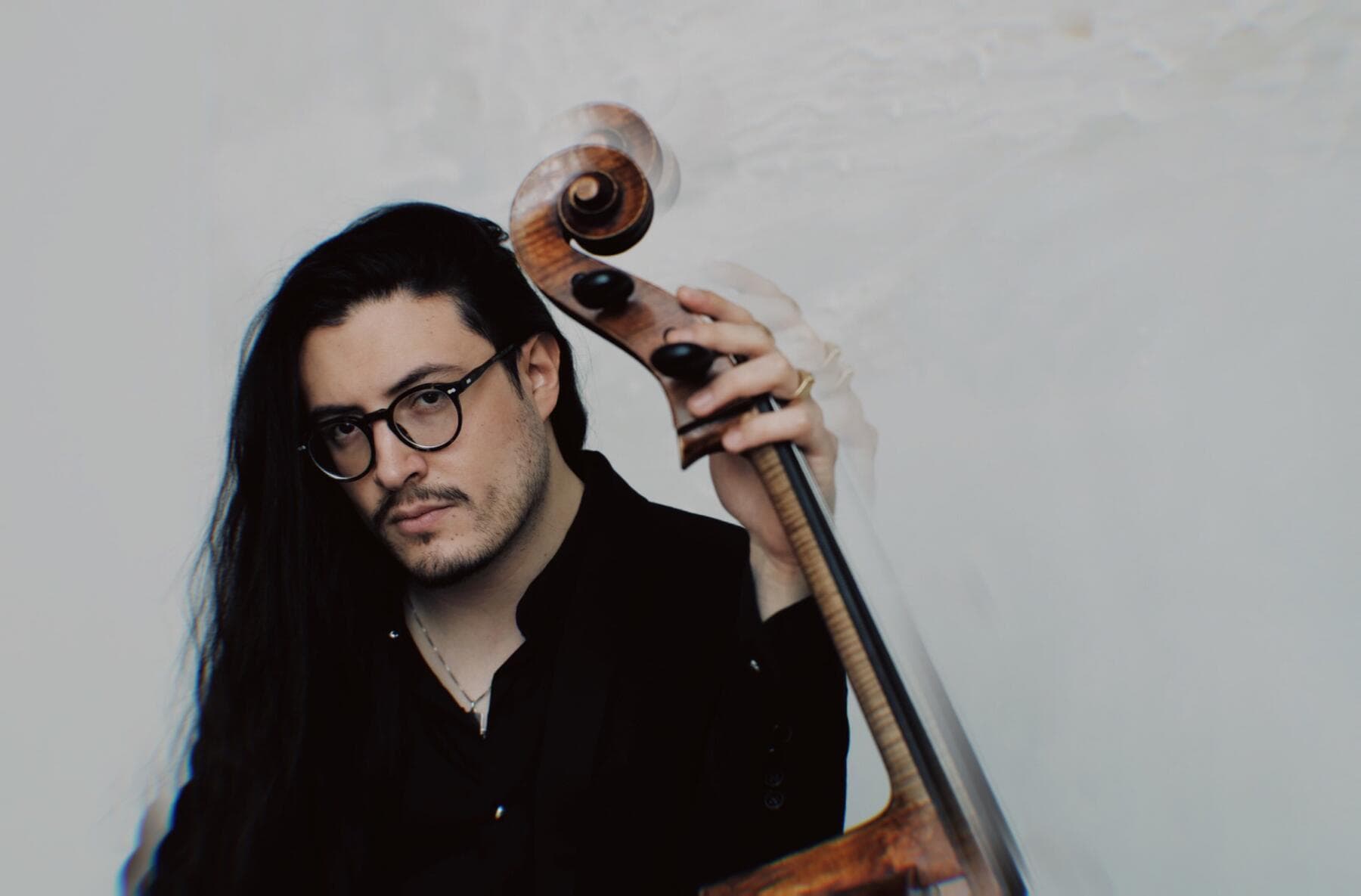 a person with long hair and glasses holding a gun