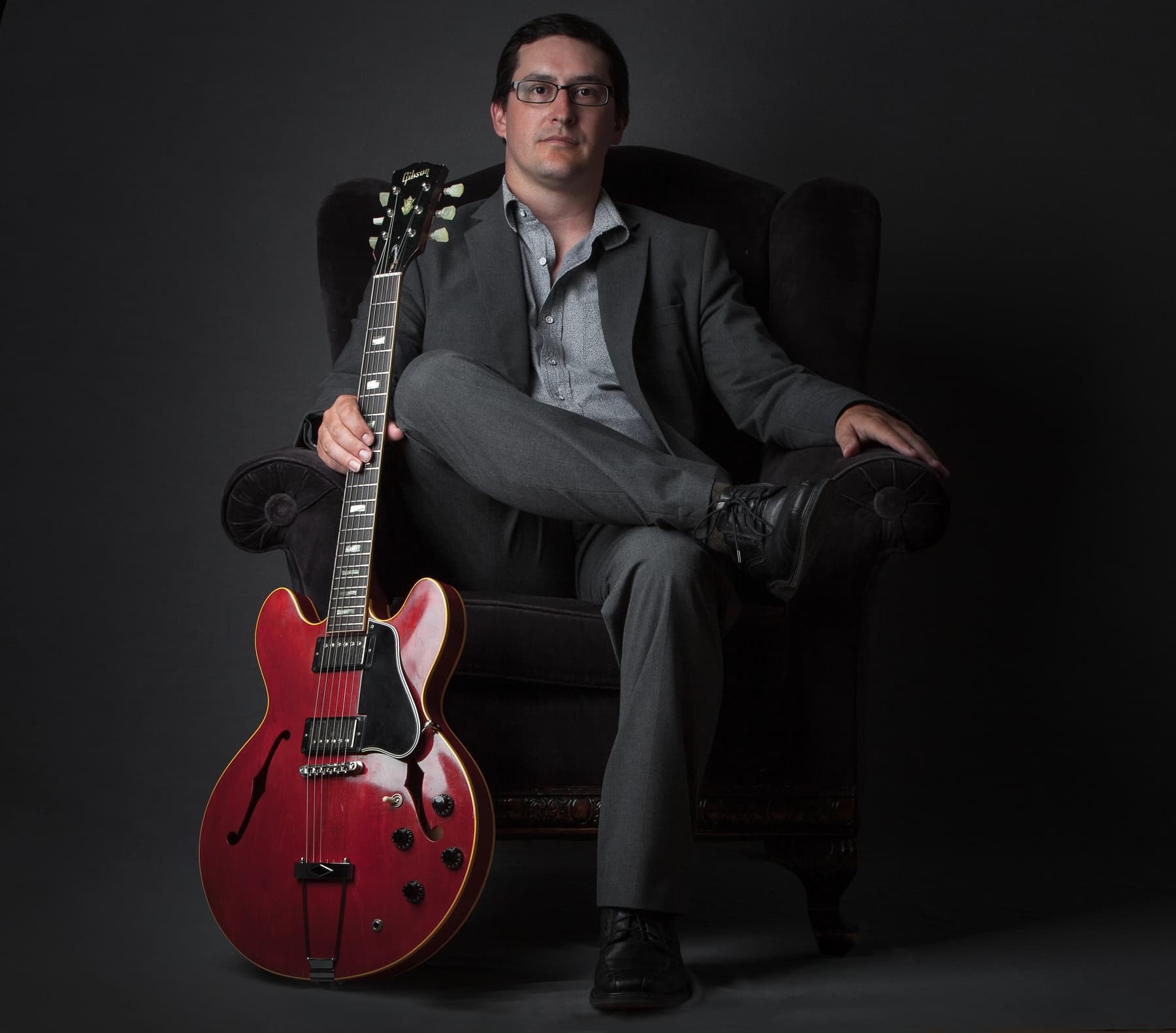 a man sitting in a chair holding a guitar