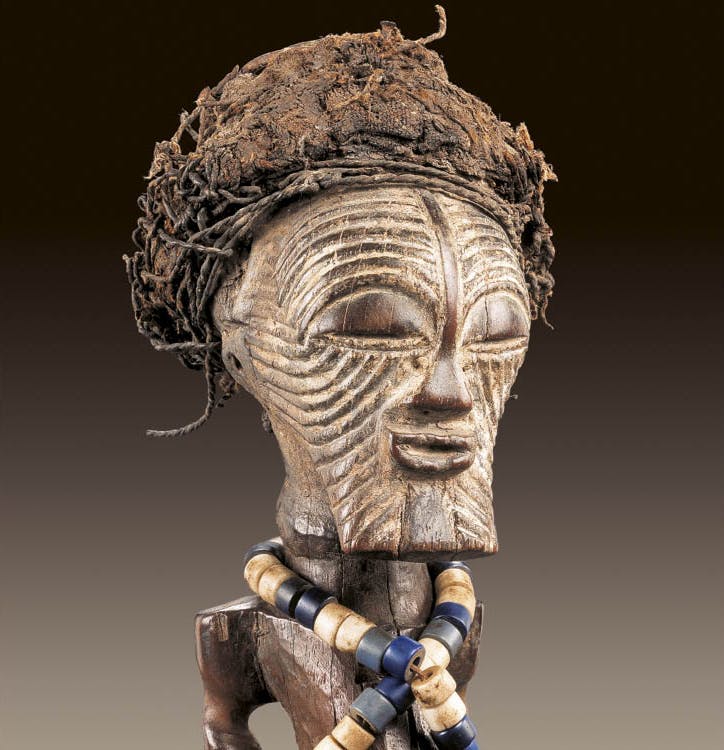 Detail of Male figure (nkishi). Songye, D.R.C. Wood, cloth, beads, iron bell, cord; h. 45 cm. Private collection. Photo: © Hughes Dubois, Paris/Brussels