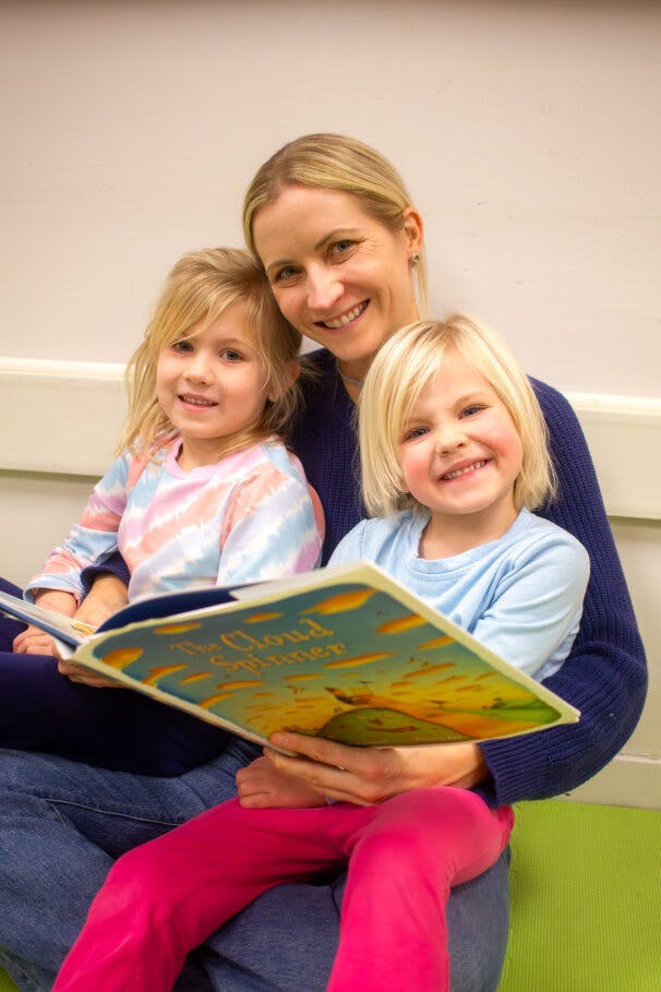Two children reading with a woman