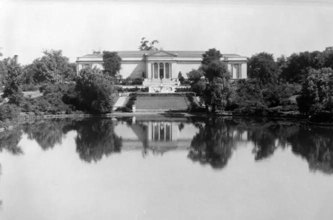 Black-and-white photograph looking over water to the white-columned façade of the Cleveland Museum of Art.