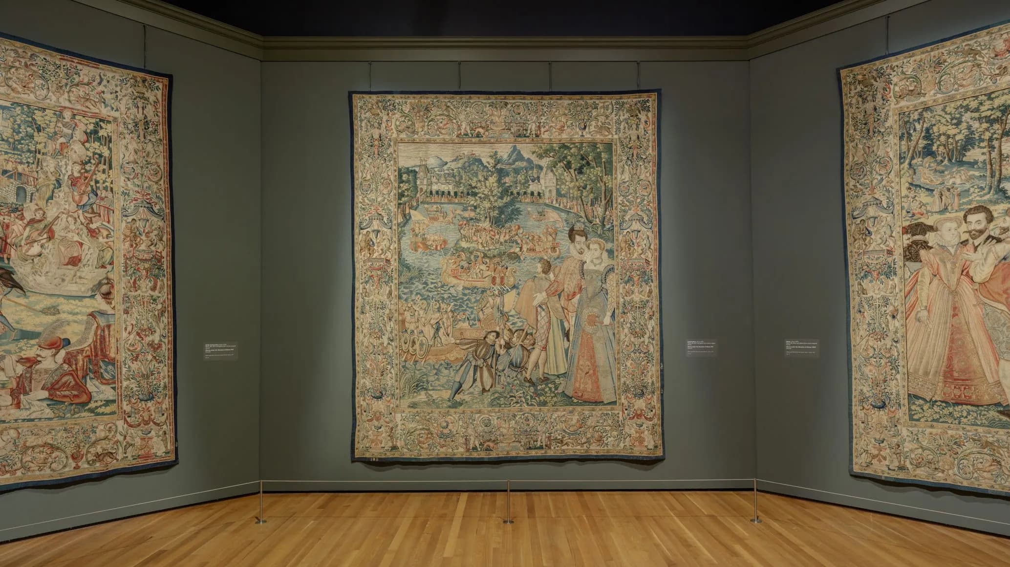 Exhibition image of three tapestries on grey walls.