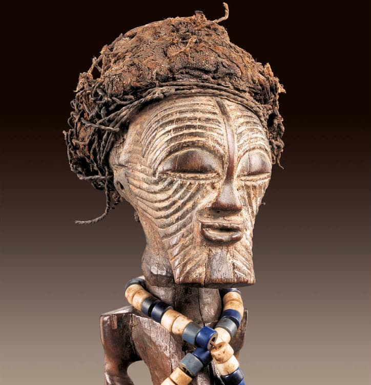 Detail of Male figure (nkishi). Songye, D.R.C. Wood, cloth, beads, iron bell, cord; h. 45 cm. Private collection. Photo: © Hughes Dubois, Paris/Brussels