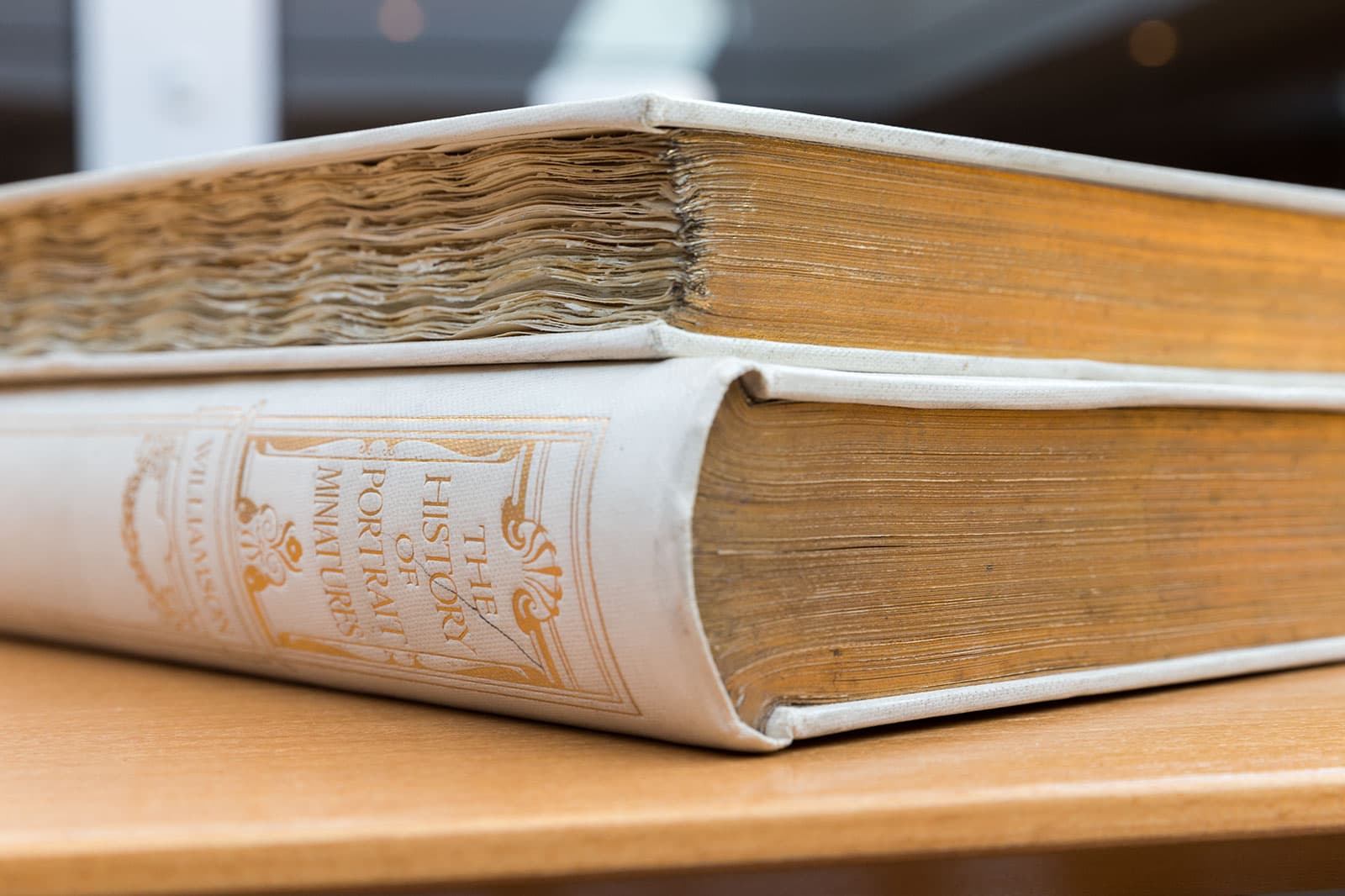 Two large beige volumes stacked on a table