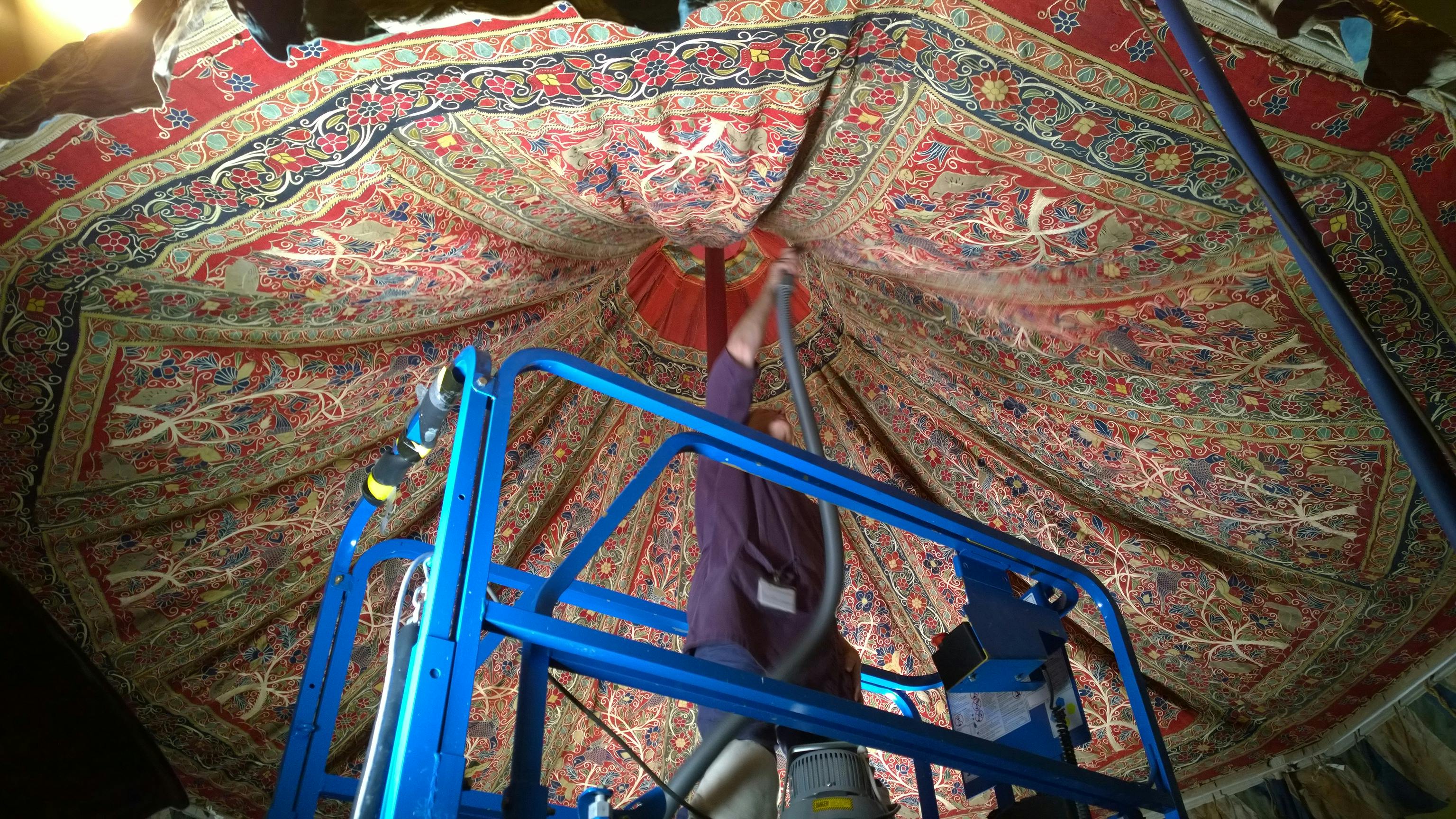 Robin Hanson, conservator of textiles, vacuuming the inside of a Qajar tent