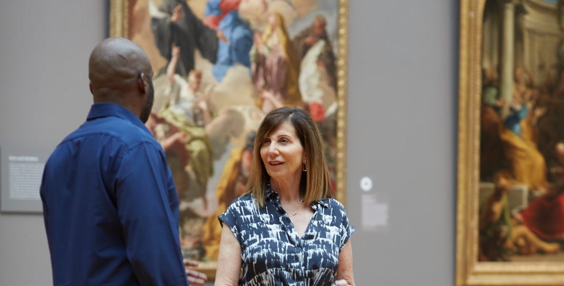 A man and woman have a conversation in the baroque galleries