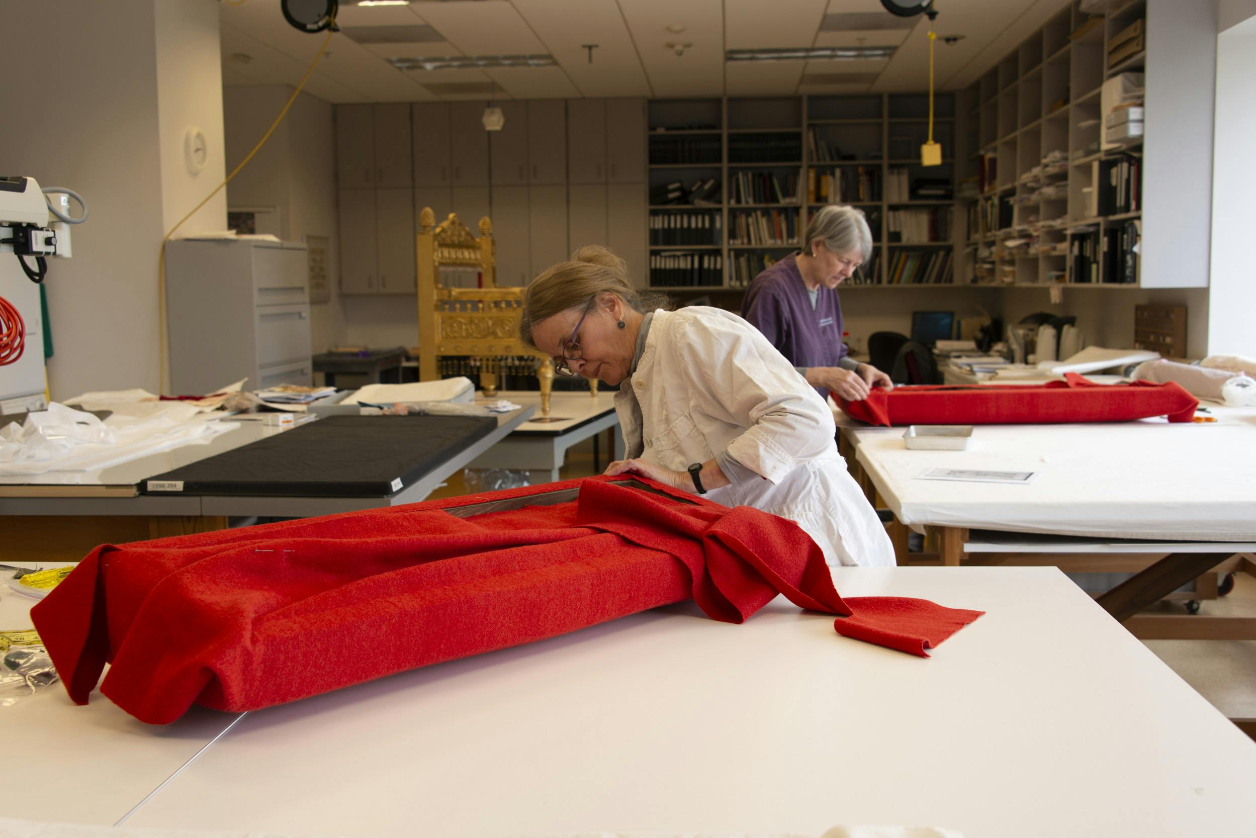 Nancy Britton, upholstery conservator at the Metropolitan Museum of Art, working with Robin Hanson, conservator of textiles at the CMA.