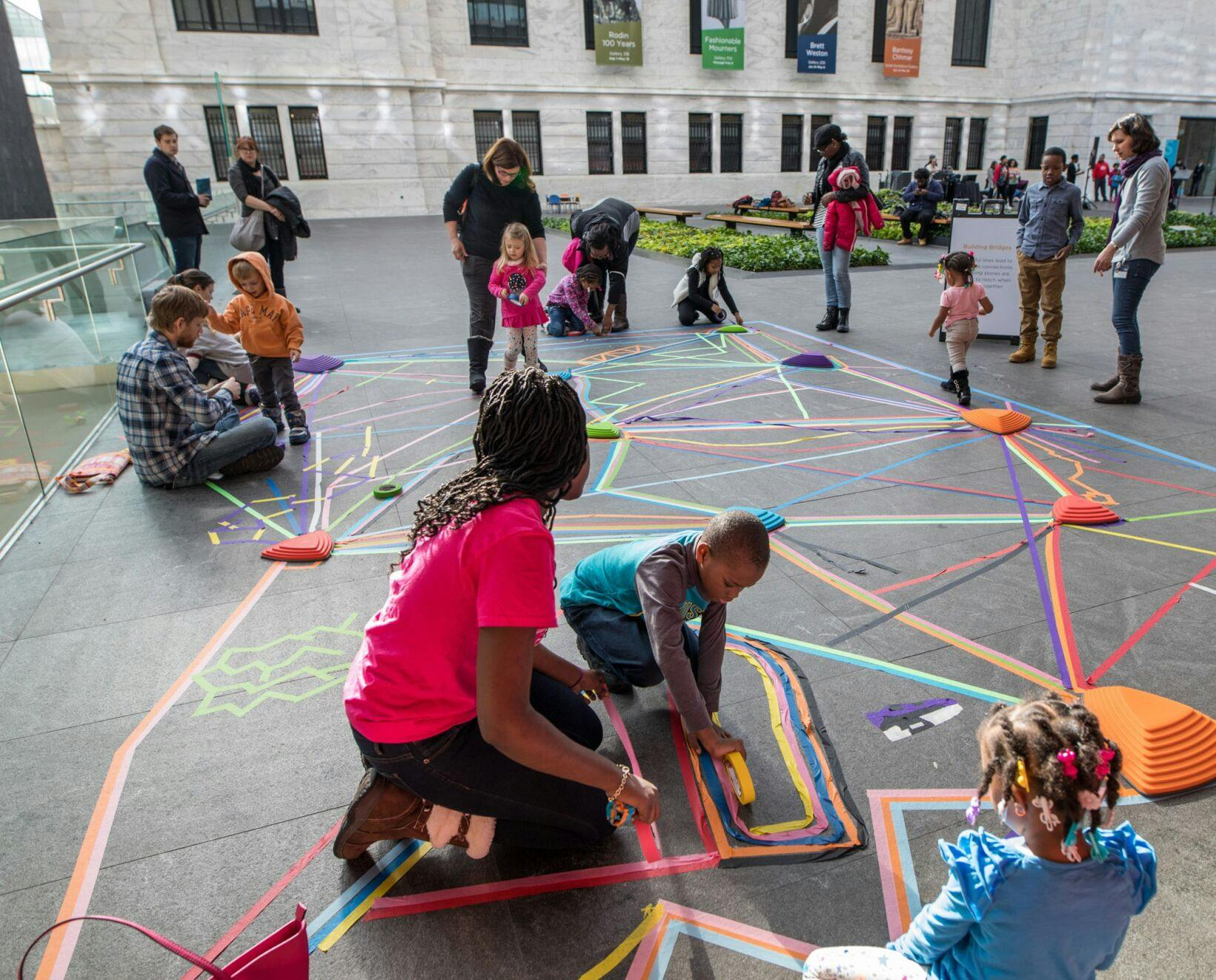 children participating in an activity using tape on the ground