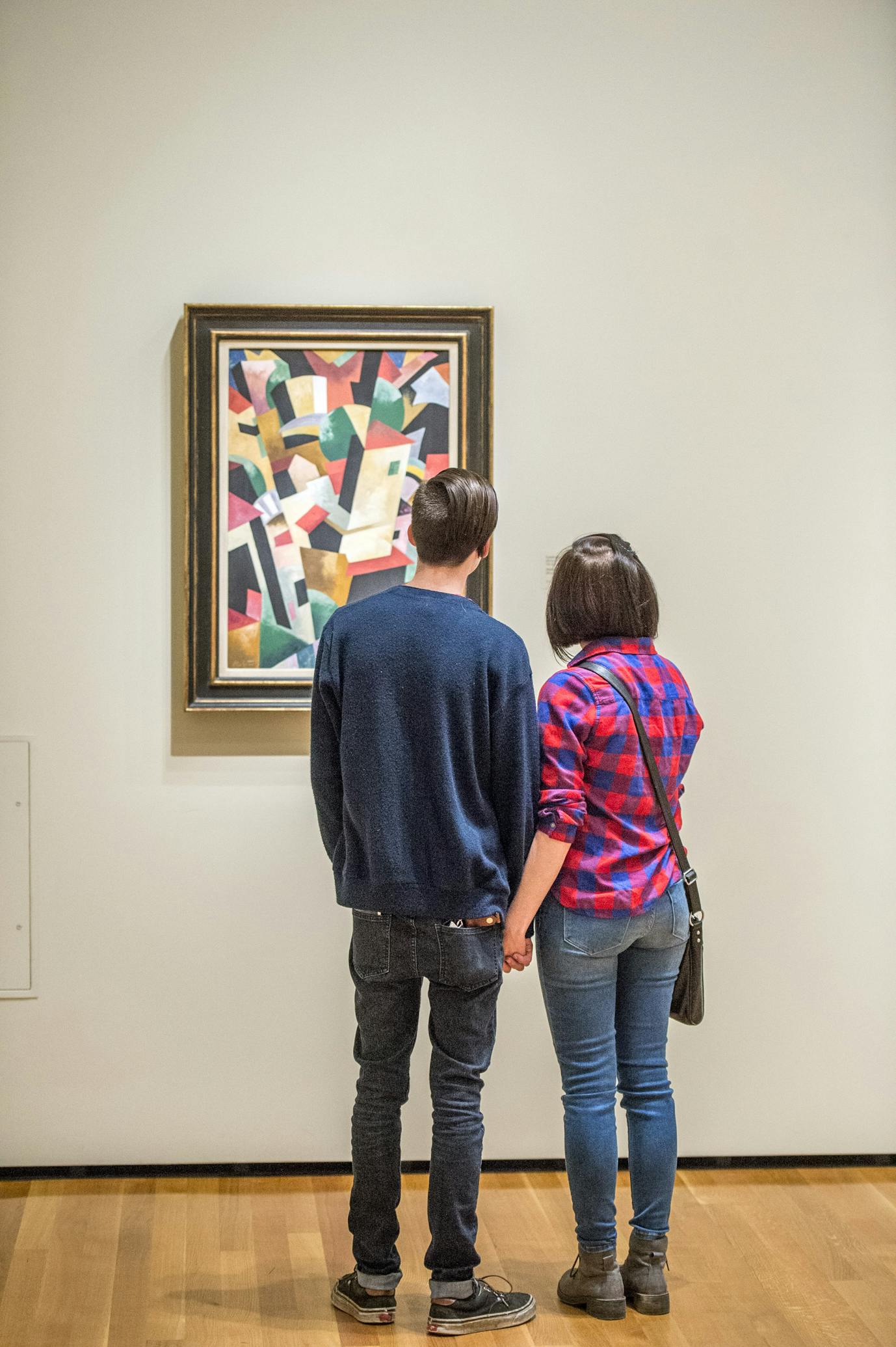 Visitors in a gallery looking at a painting