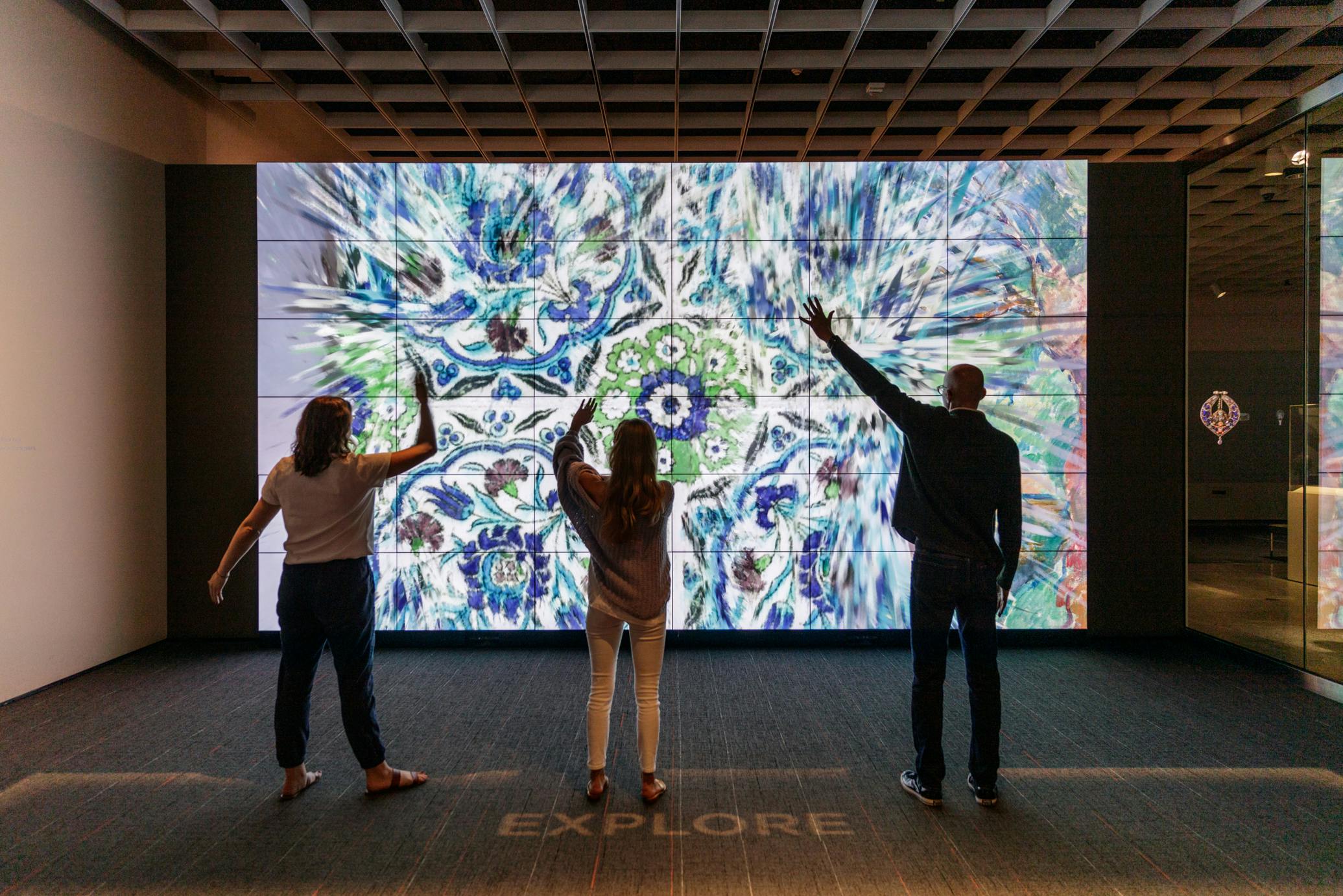 Group of three people in front of one of the ArtLens games 