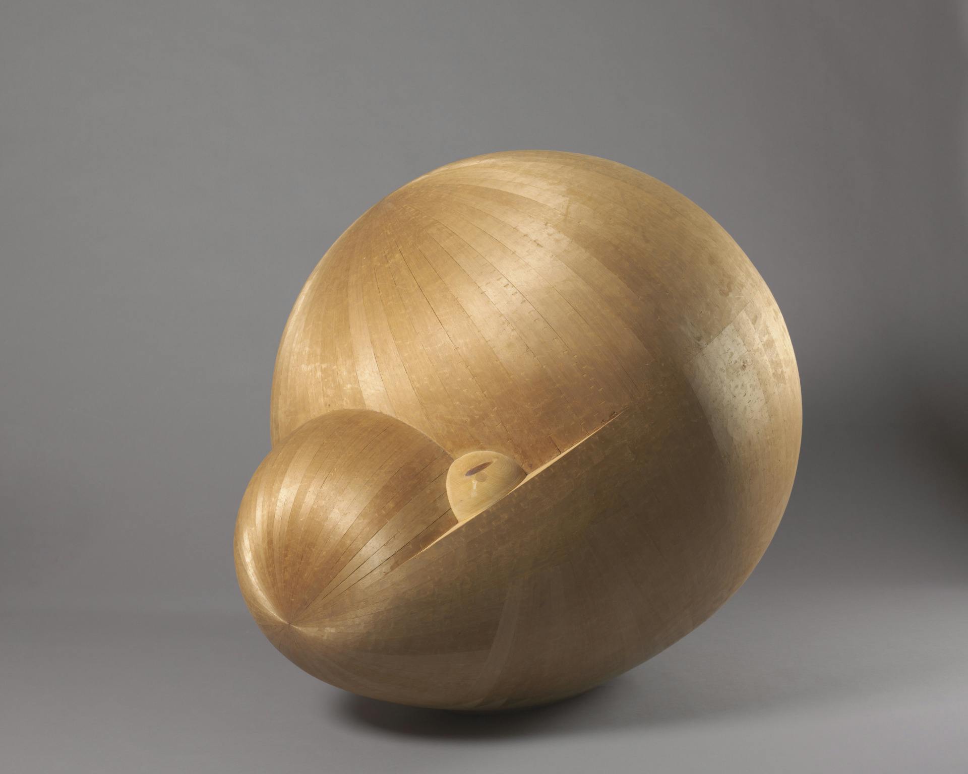 spherical straw colored sculpture with a soft sheen